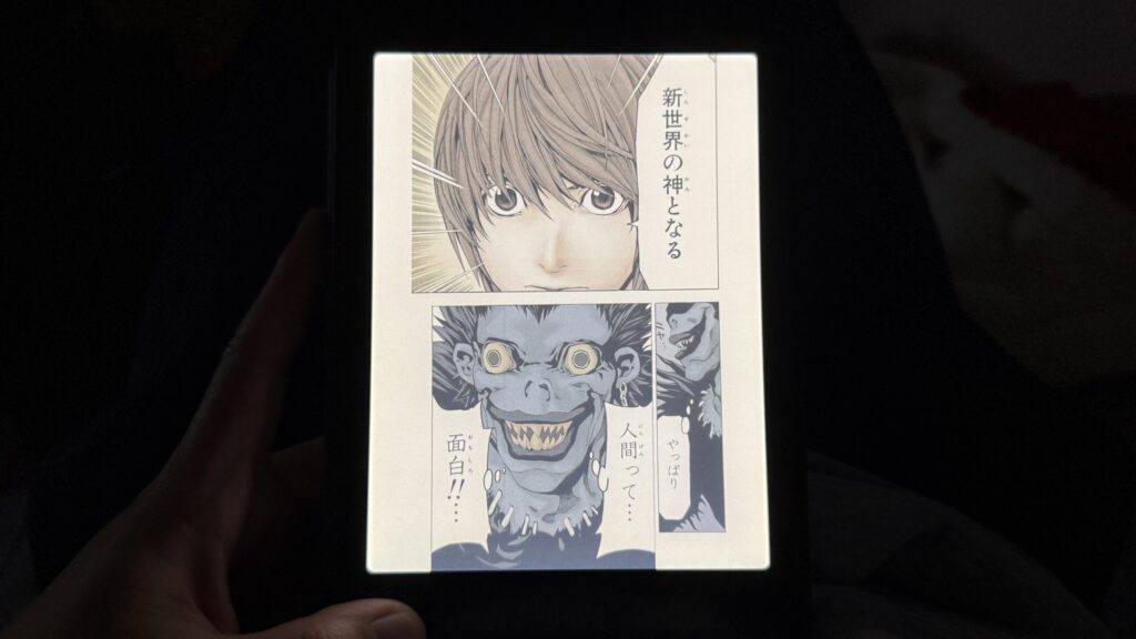 Kindle端末を使って暗い部屋のベッドで読んでいる様子